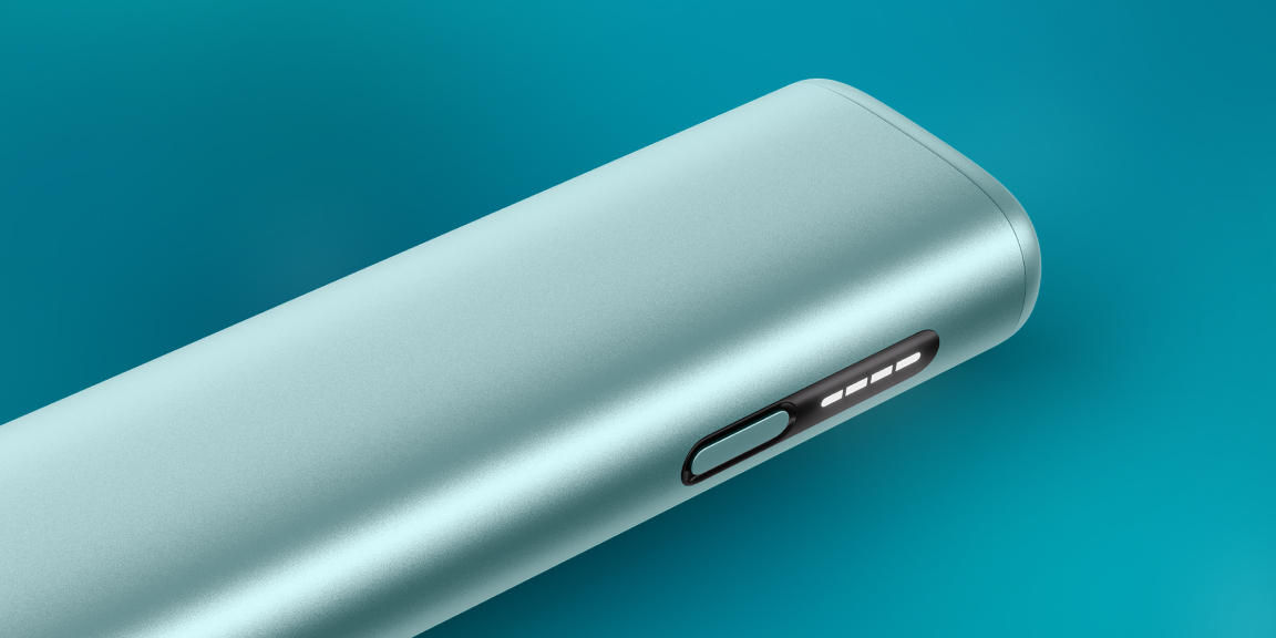 Garnet Red IQOS ILUMA i device and its charger on a brown notebook